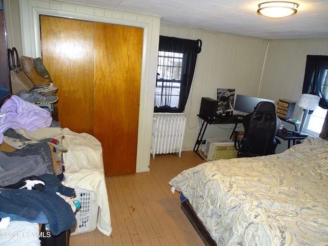 bedroom with a closet, radiator, and light hardwood / wood-style flooring