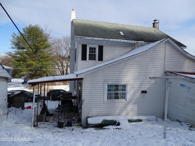 snow covered property featuring a carport