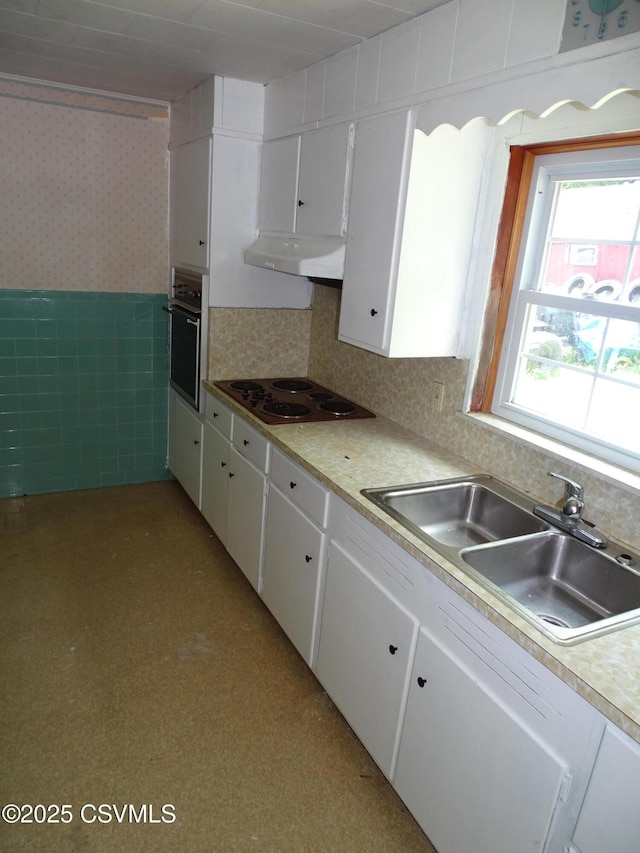 263 State Route 2026, Coal Township, PA 17866 - kitchen with stainless steel oven, electric cooktop, under cabinet range hood, a sink, and white cabinets