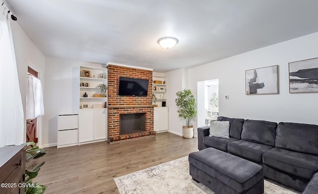 living room featuring hardwood / wood-style flooring and a brick fireplace