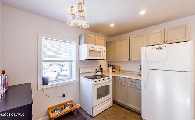 kitchen featuring decorative light fixtures, a chandelier, dark hardwood / wood-style flooring, white appliances, and cream cabinetry