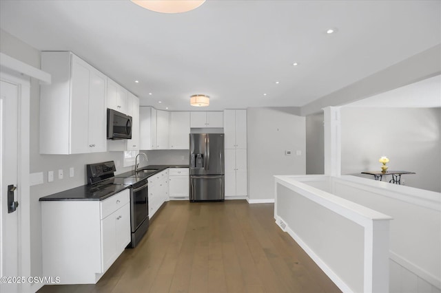 kitchen featuring stainless steel appliances, white cabinetry, sink, and dark hardwood / wood-style floors