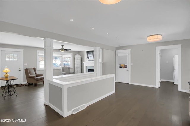 kitchen with dark hardwood / wood-style flooring, ceiling fan, and ornate columns