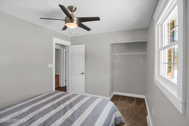 unfurnished bedroom featuring dark colored carpet, ceiling fan, and a closet