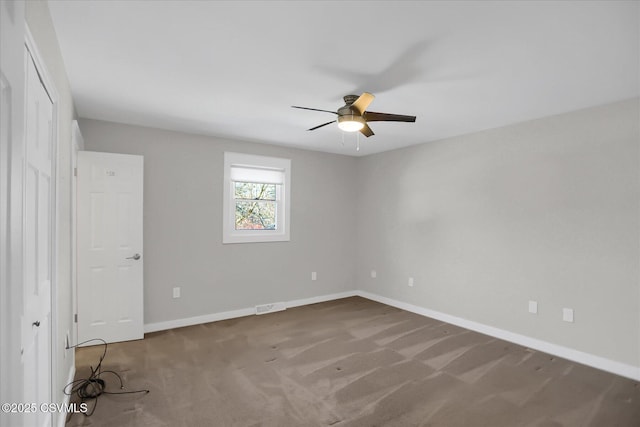 carpeted spare room featuring ceiling fan