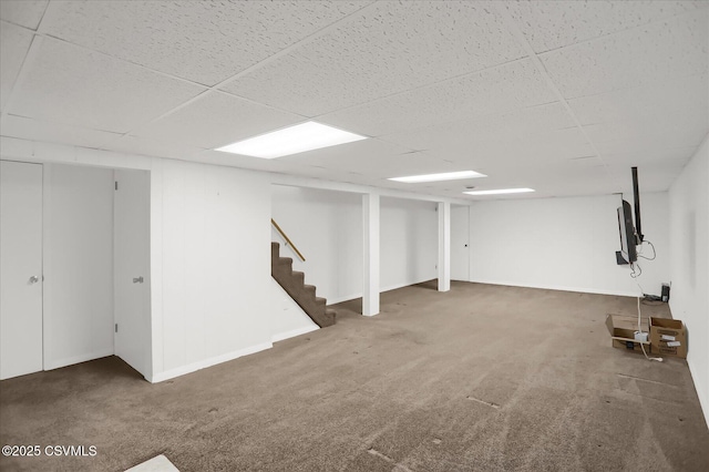 basement with dark colored carpet and a paneled ceiling