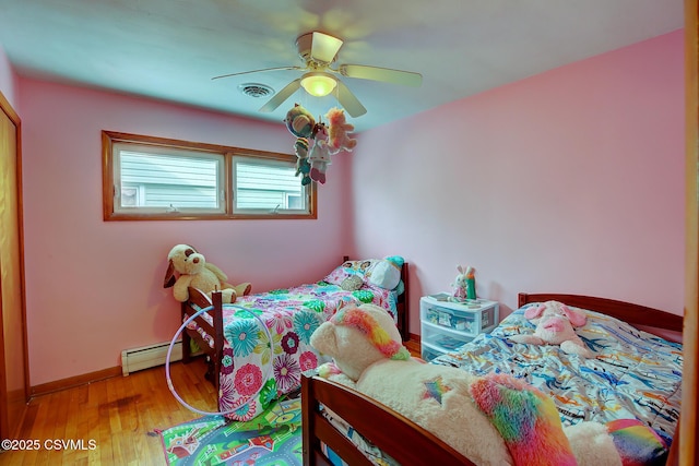 bedroom with a baseboard heating unit, ceiling fan, and light hardwood / wood-style flooring