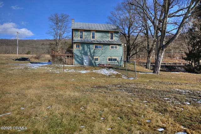 back of property with a wooden deck and a yard