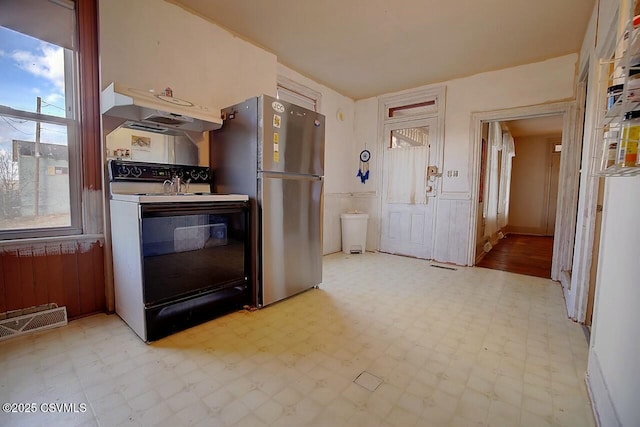 kitchen featuring electric range oven and stainless steel fridge