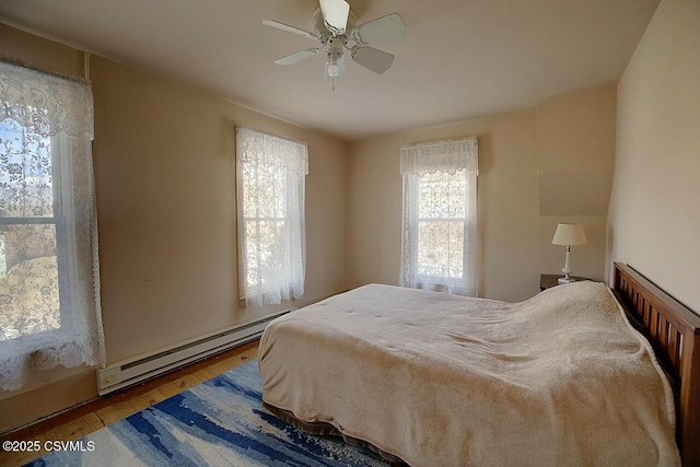 bedroom with hardwood / wood-style flooring, ceiling fan, and baseboard heating