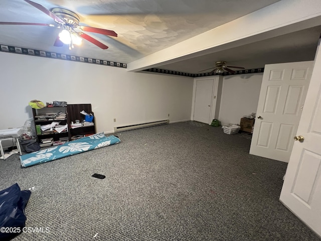 basement with a baseboard radiator, ceiling fan, and dark carpet