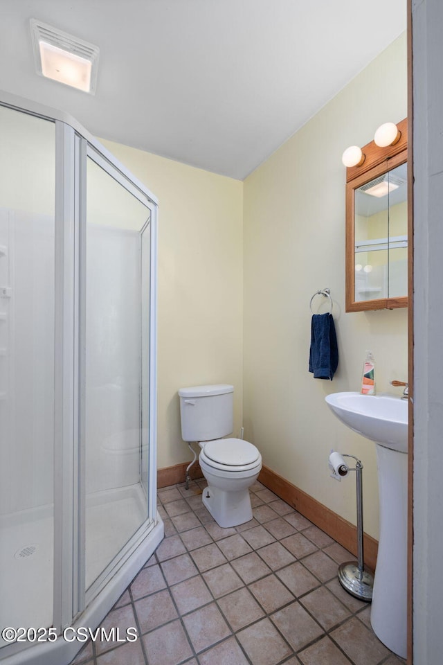 bathroom featuring tile patterned flooring, toilet, an enclosed shower, and sink