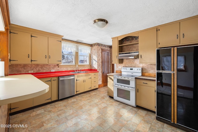 kitchen with sink, a textured ceiling, black refrigerator, dishwasher, and range with two ovens