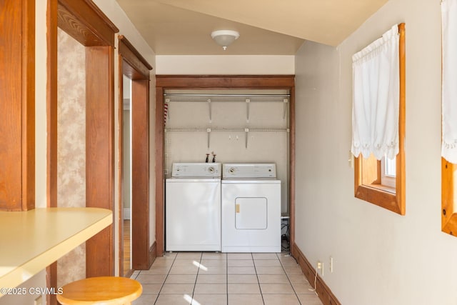 clothes washing area with light tile patterned floors and washer and clothes dryer