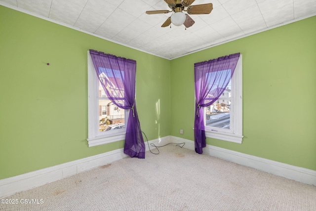 unfurnished room featuring a wealth of natural light, ceiling fan, and carpet