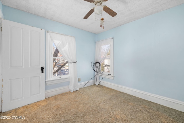 carpeted spare room with ceiling fan and a textured ceiling