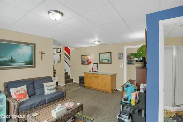 living room featuring a paneled ceiling and carpet