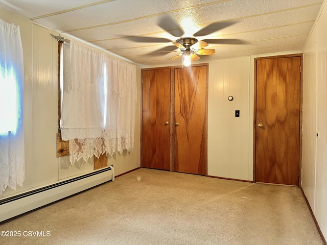 unfurnished room featuring light colored carpet, ceiling fan, and baseboard heating