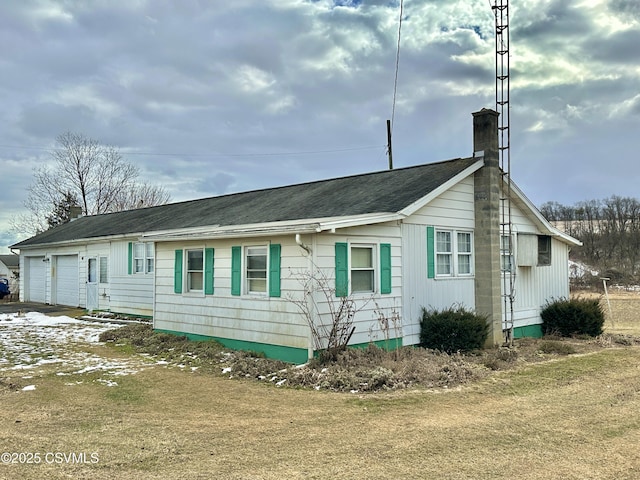 view of home's exterior with a garage and a lawn