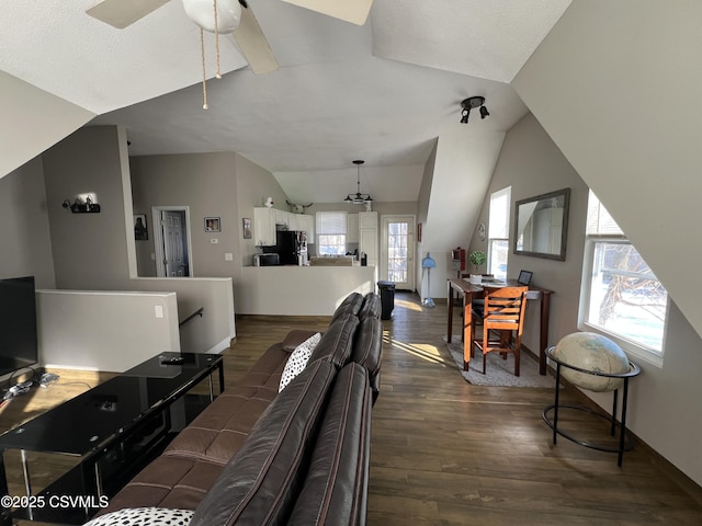 living room with dark wood-type flooring, vaulted ceiling, and ceiling fan