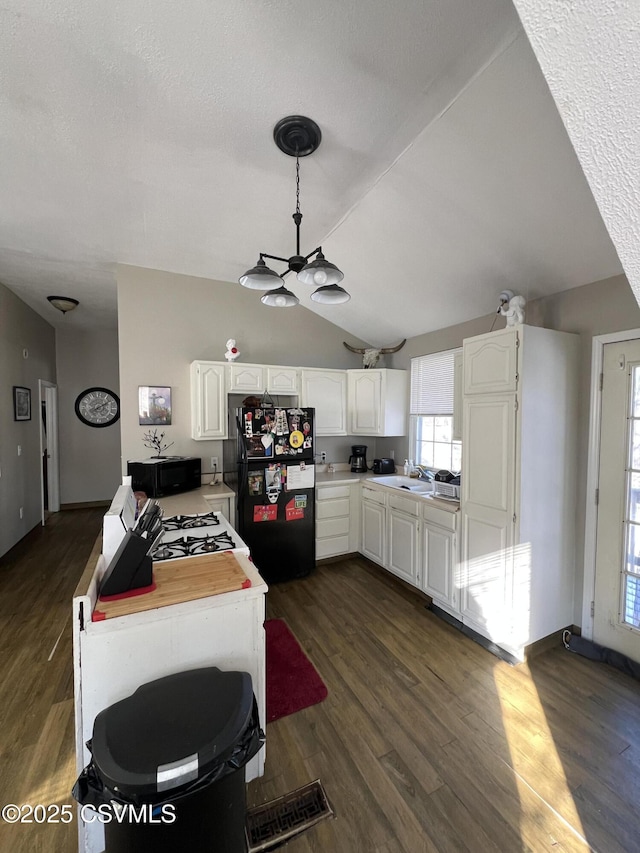 kitchen featuring white cabinetry, lofted ceiling, dark hardwood / wood-style flooring, and black appliances