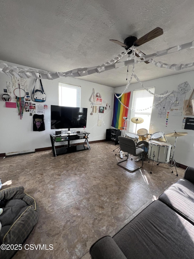 living room with ceiling fan and a textured ceiling