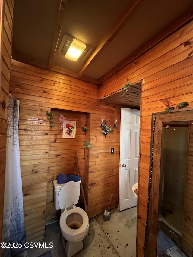 bathroom with wooden walls and toilet