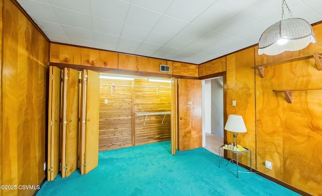 unfurnished bedroom with light colored carpet and wooden walls