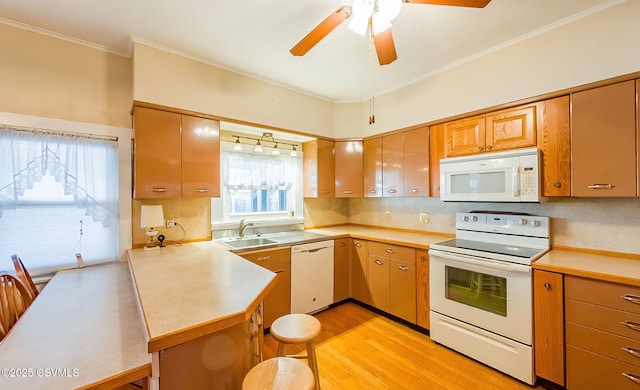 kitchen featuring sink, light wood-type flooring, kitchen peninsula, white appliances, and backsplash