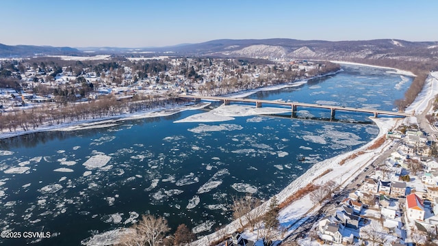 snowy aerial view with a water and mountain view