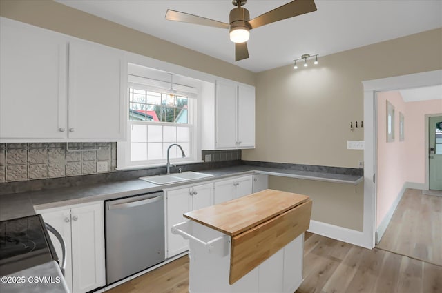 kitchen with appliances with stainless steel finishes, sink, white cabinets, and light wood-type flooring