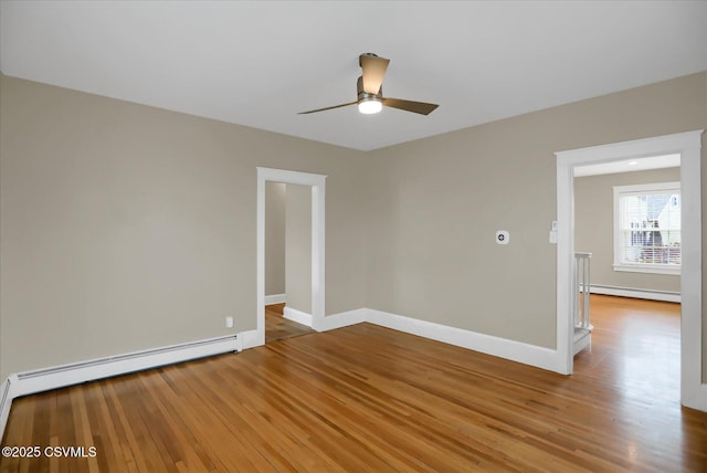 spare room with hardwood / wood-style floors, ceiling fan, and baseboard heating