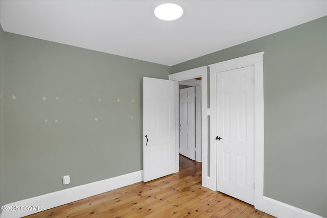 unfurnished bedroom featuring wood-type flooring and a closet