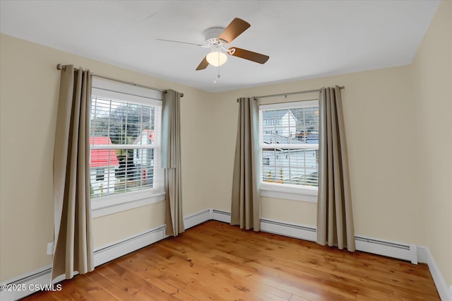 empty room with ceiling fan, a baseboard radiator, light hardwood / wood-style floors, and a healthy amount of sunlight