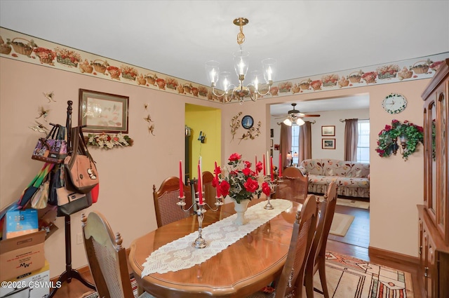 dining area featuring ceiling fan with notable chandelier and light hardwood / wood-style flooring