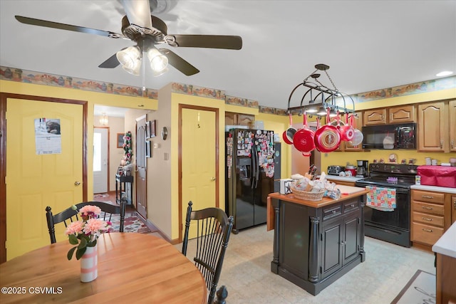 kitchen with decorative light fixtures, a kitchen island, and black appliances