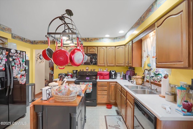 kitchen featuring decorative light fixtures, sink, and black appliances