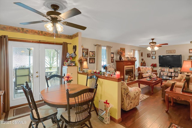 dining area with wood-type flooring, ceiling fan, and french doors