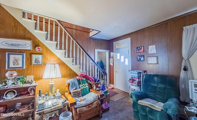 living area featuring wooden walls and carpet flooring