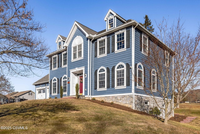 colonial inspired home featuring a front lawn