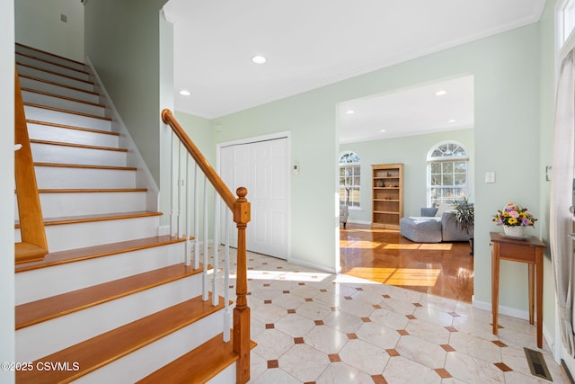 foyer entrance featuring light tile patterned floors and ornamental molding