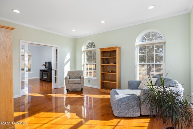 living area featuring ornamental molding, plenty of natural light, and wood-type flooring