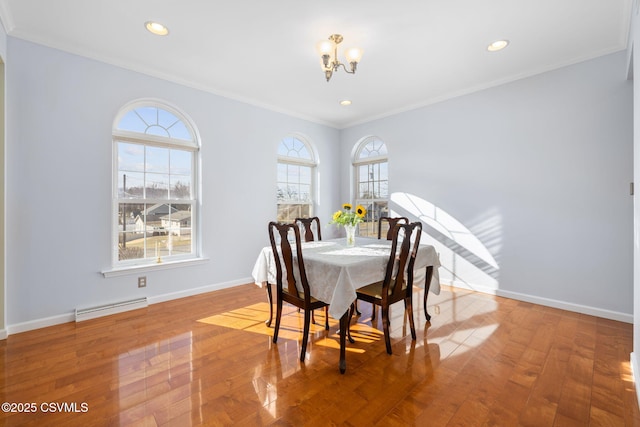 dining space with a notable chandelier, crown molding, and wood-type flooring