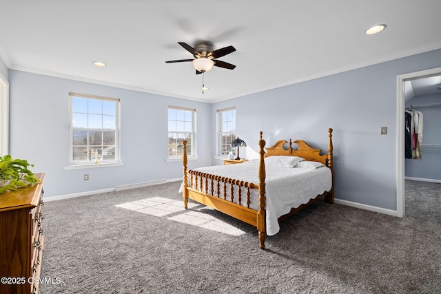 carpeted bedroom featuring multiple windows, crown molding, and a walk in closet