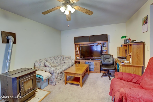 living room featuring light carpet, ceiling fan, and a wood stove