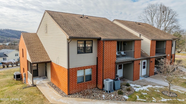 view of front of property featuring a balcony and central air condition unit