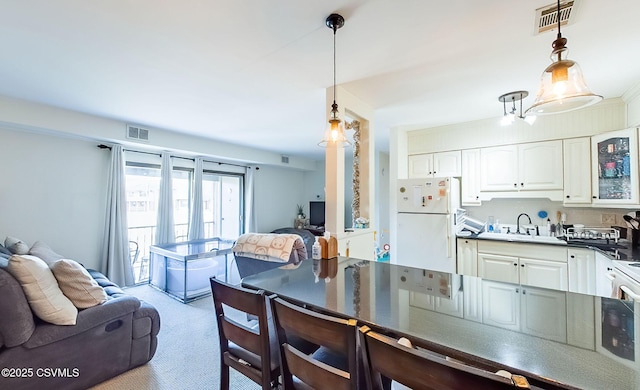 dining area with sink and light colored carpet