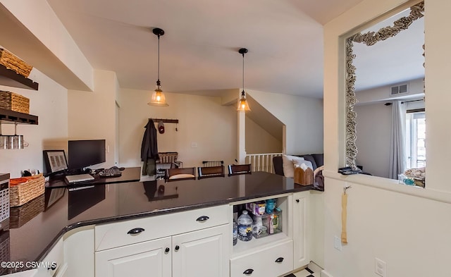 kitchen featuring decorative light fixtures, kitchen peninsula, and white cabinets