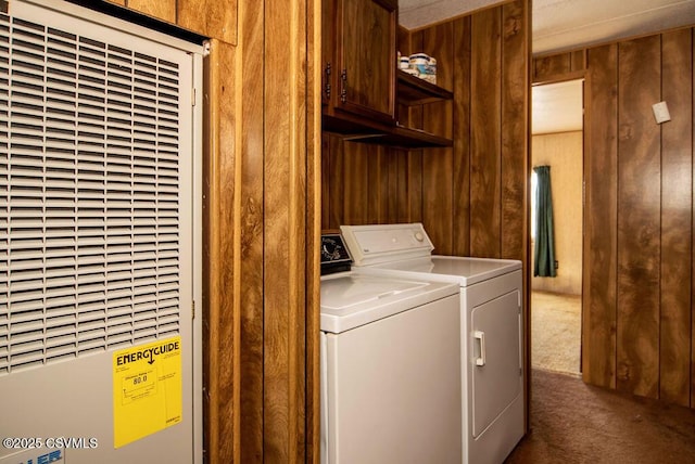 laundry room with cabinets, carpet, washer and dryer, and wood walls