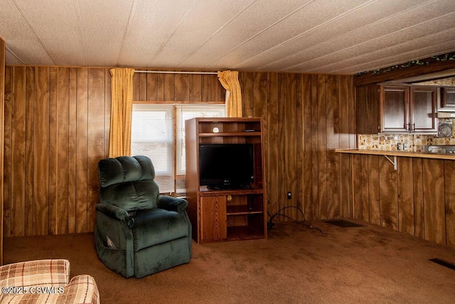 living area with carpet flooring and wooden walls